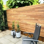 Contemporary wooden fence with 7.0 cm slats horizontally mounted with mounting clips of ipe hardwood