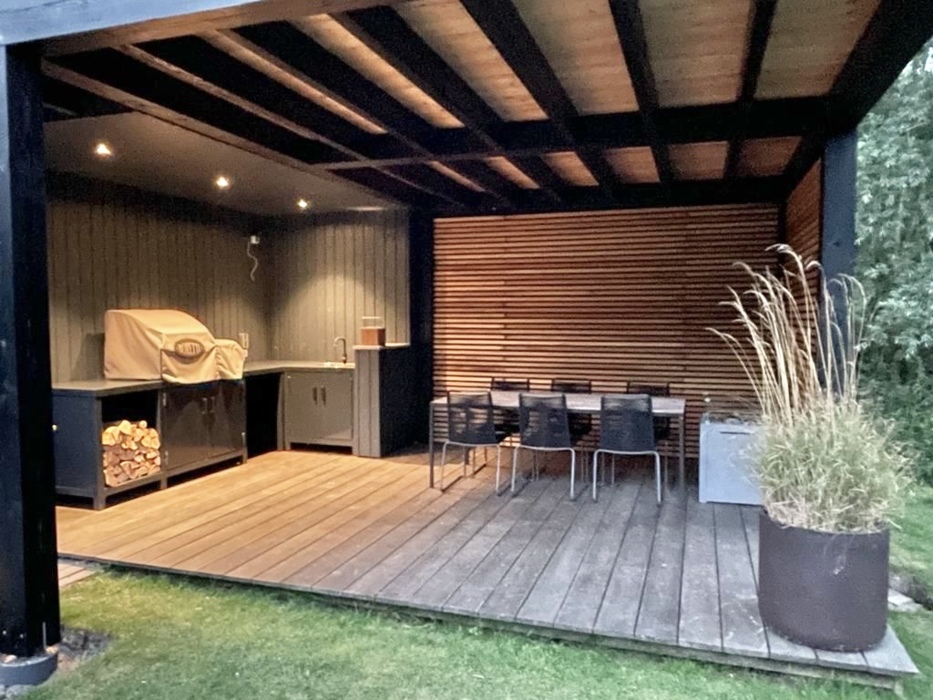 Luxury mancave garden structure featuring matching decking and a slatted wall made of 4 cm timber beams