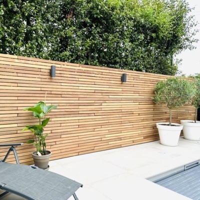 Contemporary garden fence constructed with premium Ipé hardwood slats, providing a high-end slatted privacy screen.